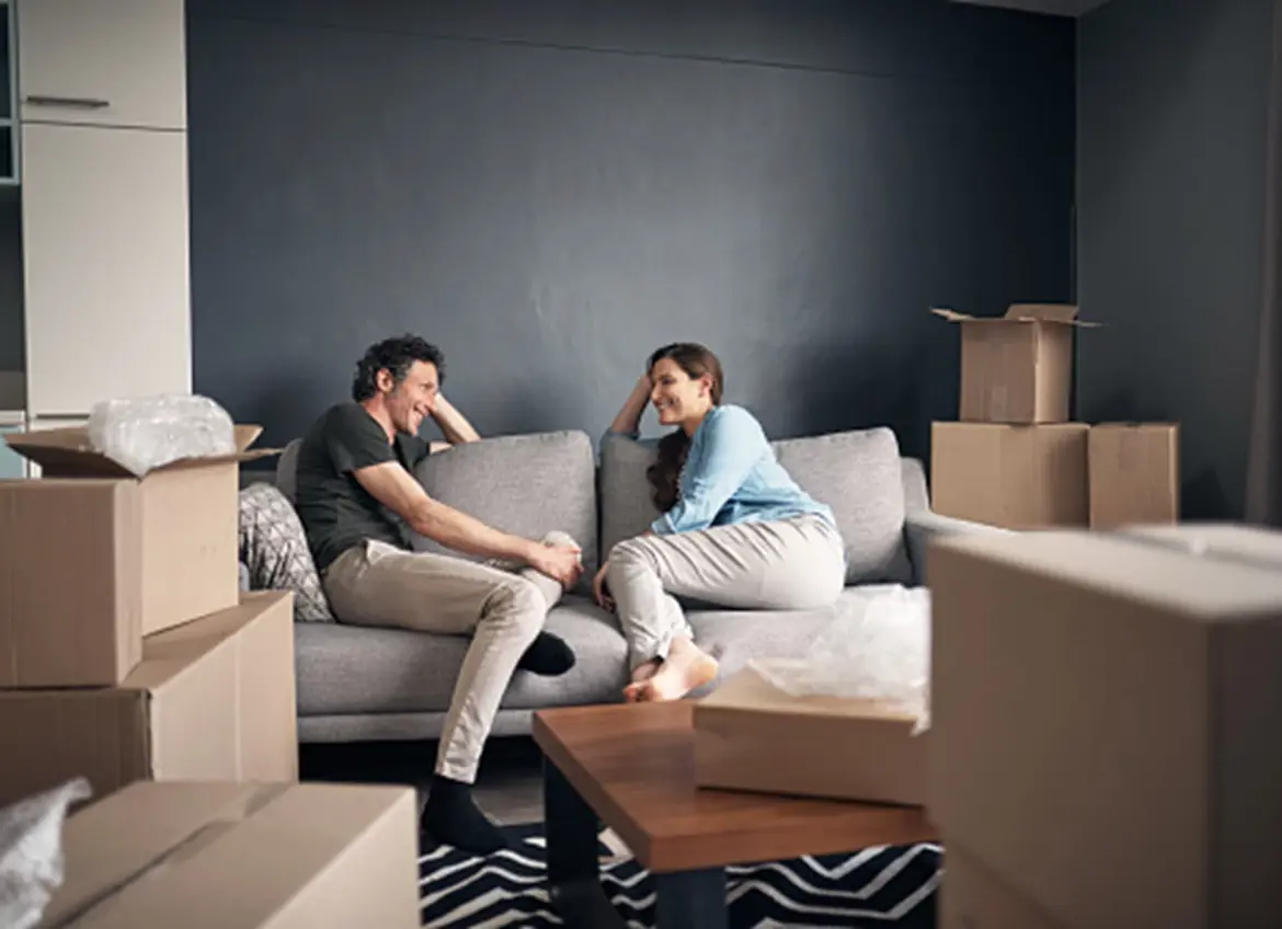 A happy couple relaxing on the sofa, surrounded by boxes