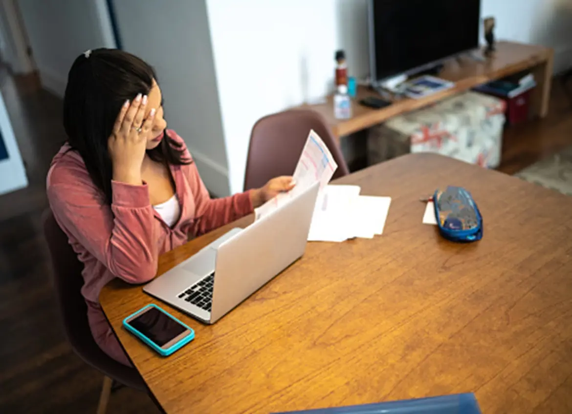 A woman looking stressed out while reviewing bills