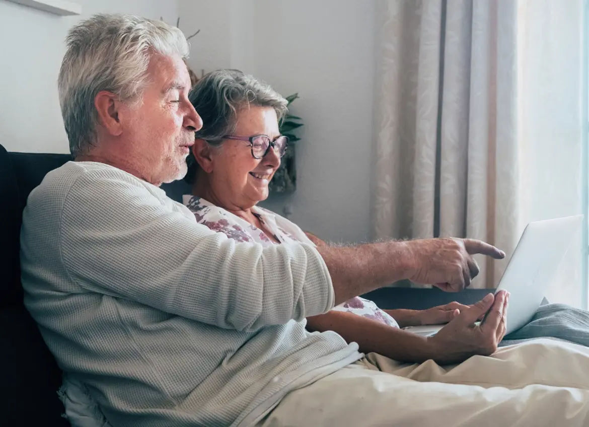 A senior couple looking at a laptop together