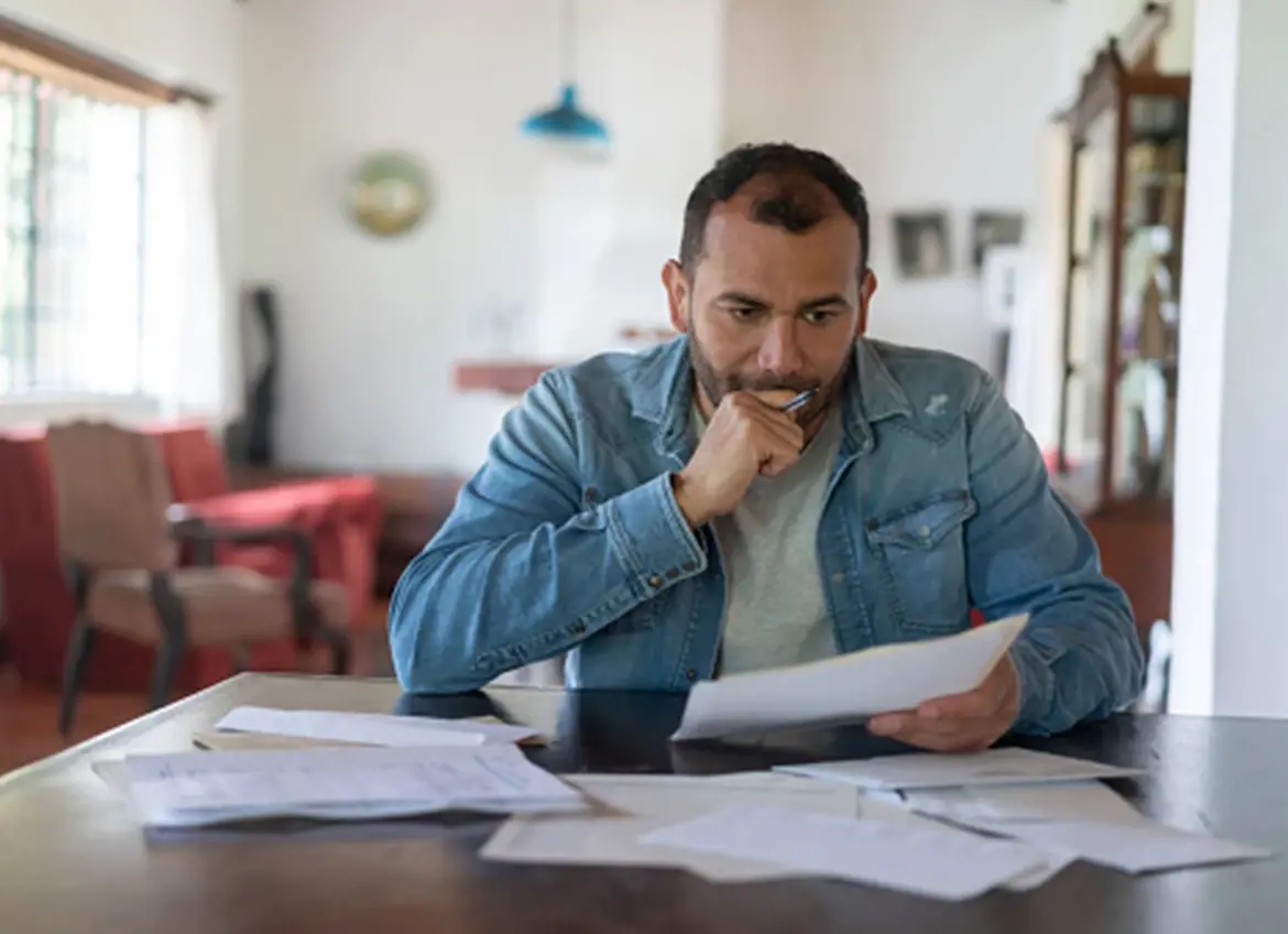 A man deep in thought while reading paperwork