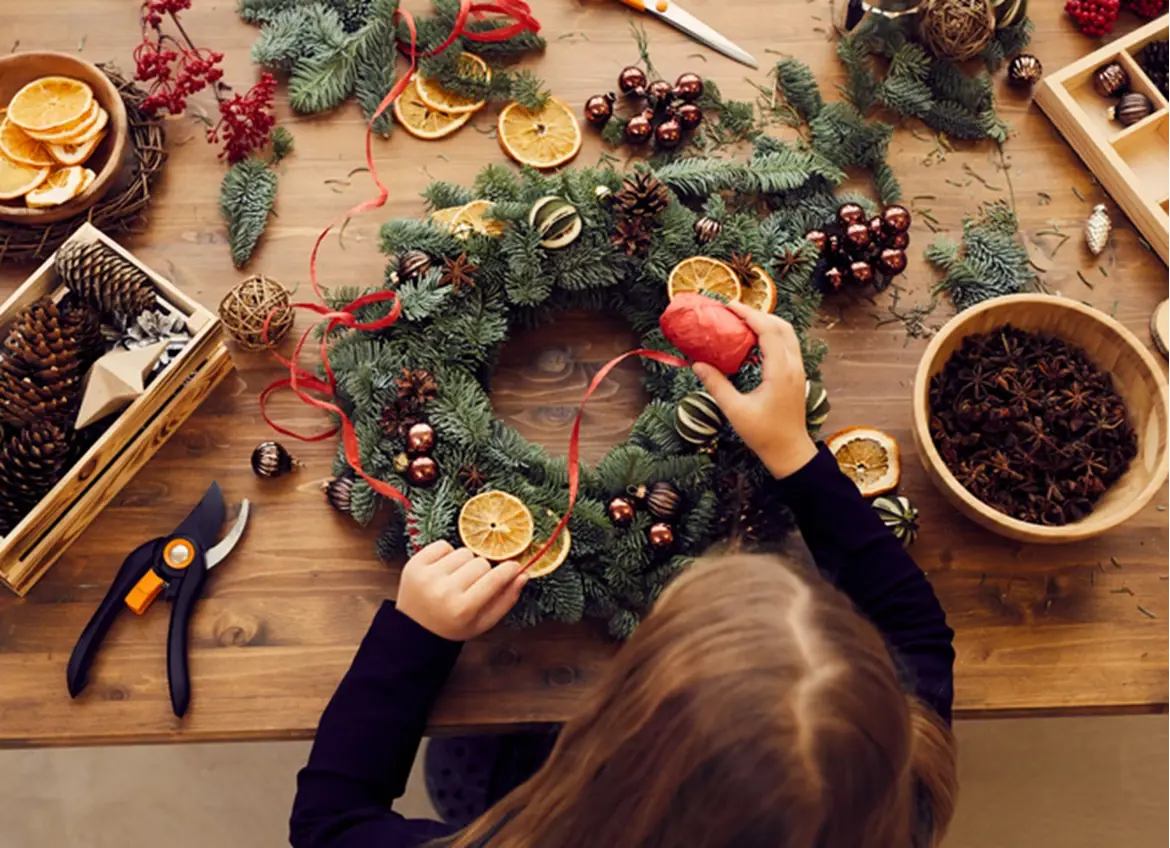 A child decorating a Christmas wrath