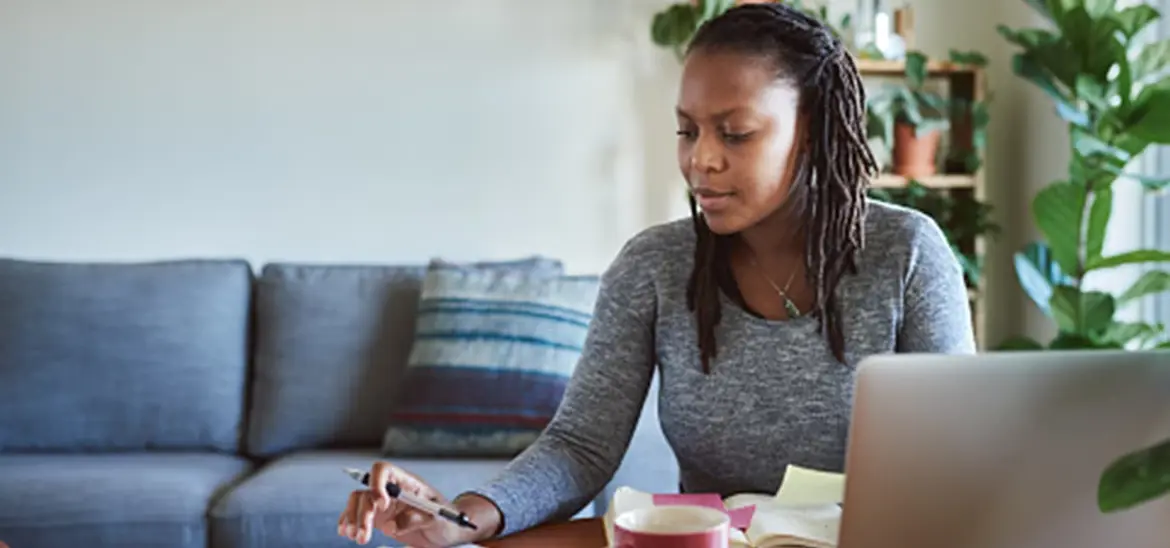 A woman using a calculator while reviewing bills