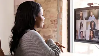 A woman in a virtual meeting on her computer