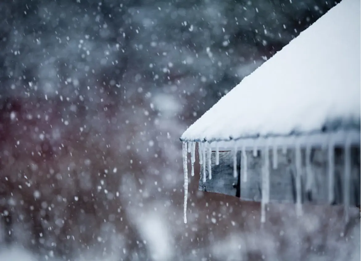 Snow covered roof with icicles