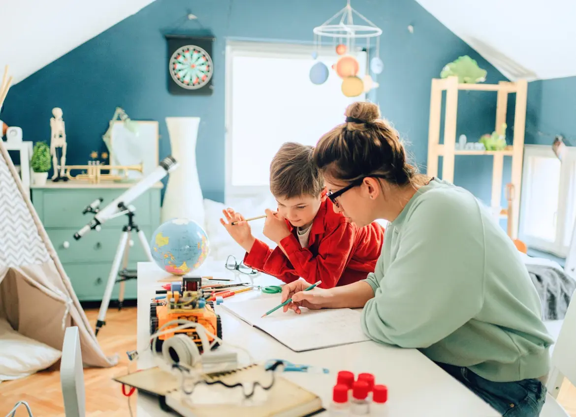 Mom helping her son with school work in his room