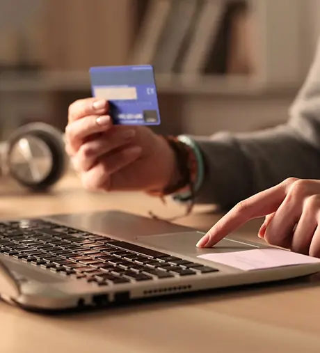 A person making a credit card payment on a laptop