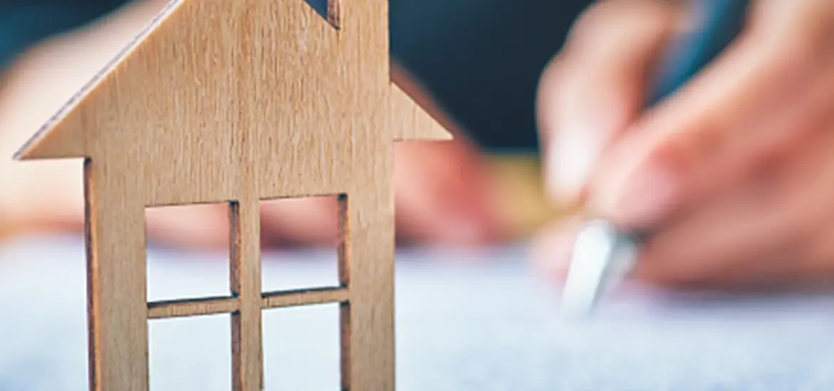 A House figurine sitting on a paperwork