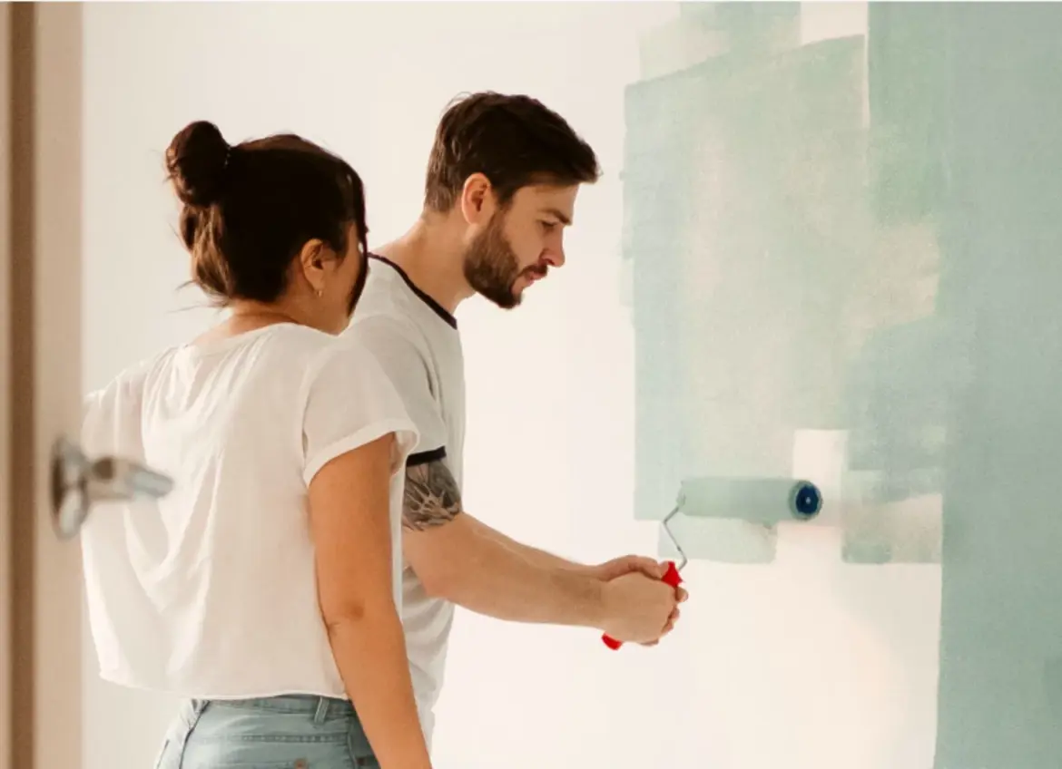 A couple painting a wall