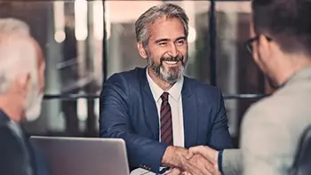 Three men in a meeting and shaking hands