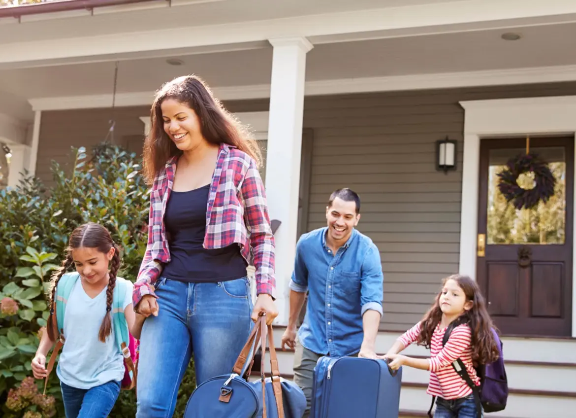 A family with two girls leaving house with luggages