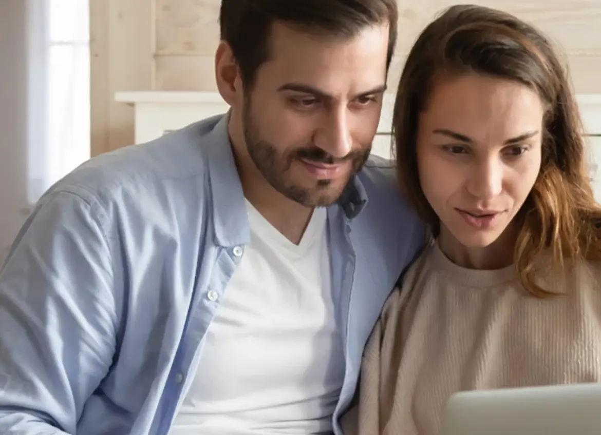 A couple looking at a laptop screen together